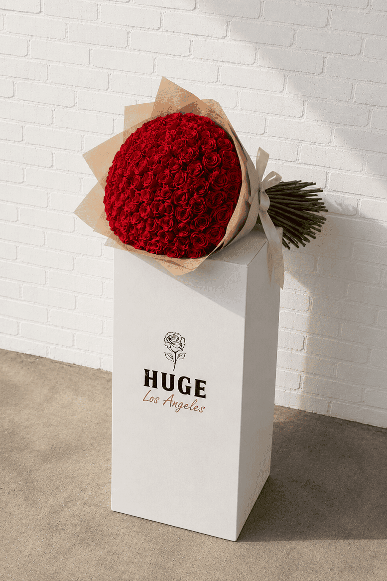 Red bouquet in a white box with 'HUGE Los Angeles' branding against a white brick wall.